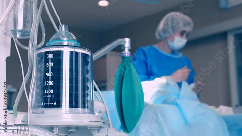 Close-up of a ventilator during an operation, 4k shot. The movement is remembered by artificial lung ventilation, amid a ward with a patient and doctors. Pneumonia and tuberculosis, Covid 19