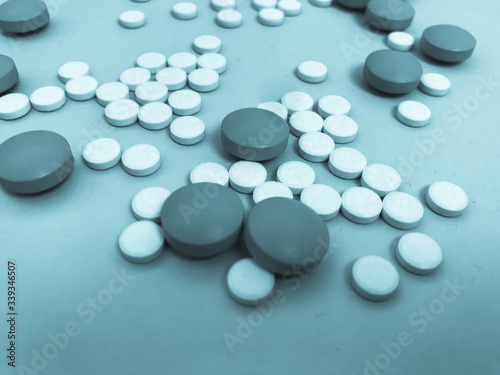 Round medical pharmaceutical medicines for the treatment of diseases and the killing of microbes and viruses pills and vitamins medicines for coronavirus gray on a blue background