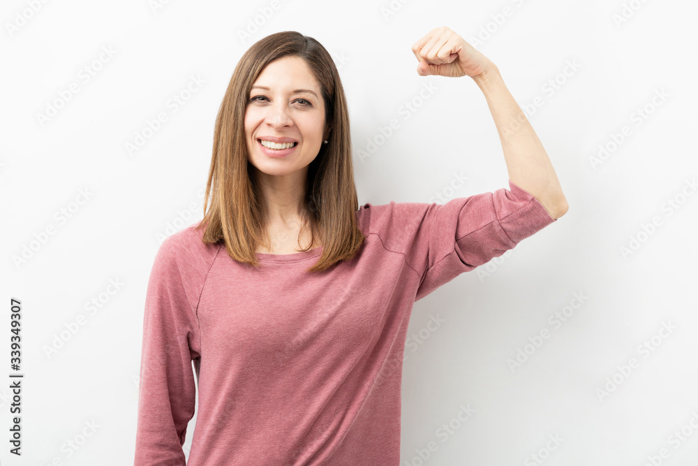 Pretty woman showing her strength and smiling Pretty woman showing her strength and smiling