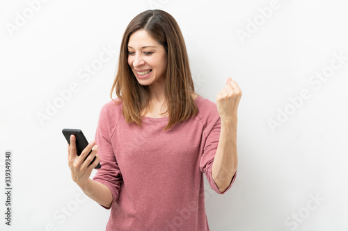 Woman looking excited while looking at her phone
