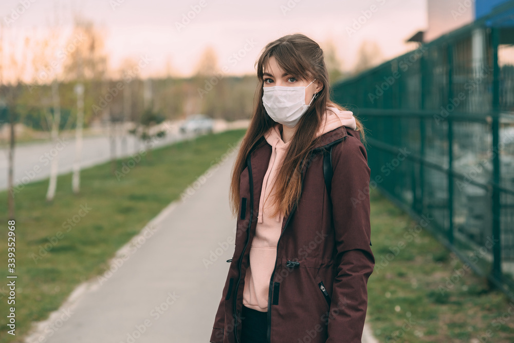 COVID-19 Pandemic coronavirus. Young girl on a city street in a protective mask to protect against illness. Close-up of a young woman with a protective mask on her face from SARS-CoV-2. COVID-19 Pandemic coronavirus. Young girl on a city street in a protective mask to protect against illness. Close-up of a young woman with a protective mask on her face from SARS-CoV-2.