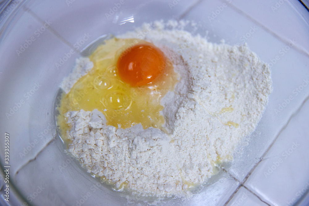 raw egg on pile of flour ingredients for pancake recipe raw egg on pile of flour ingredients for pancake recipe