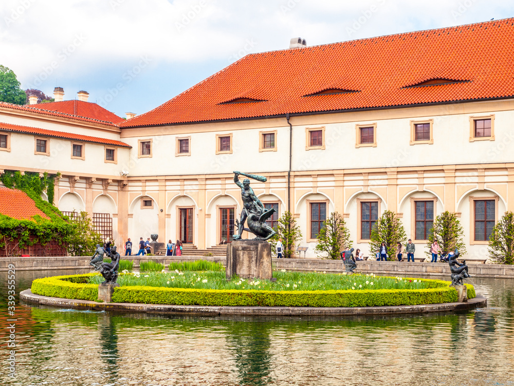 Pool with small island and statue in baroque Wallenstein palace garden, Wallenstein Riding Hall on background, Prague, Czech Republic