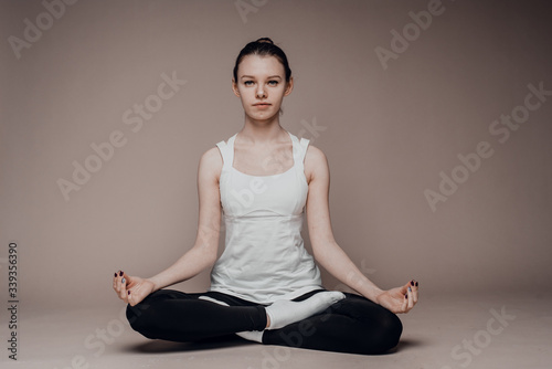 A girl sits in a lotus position and meditates with her eyes closed. Zen practice, breath technique. Consideration and praying