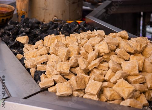 Delicious fried black stinky Tofu (smelly tofu) and yellow tofu in steel tray at night market, famous small food in China.