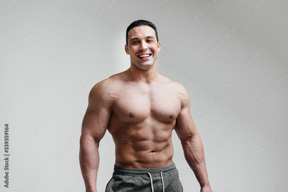 Sporty, sexy athlete smiling on a white background. Fitness