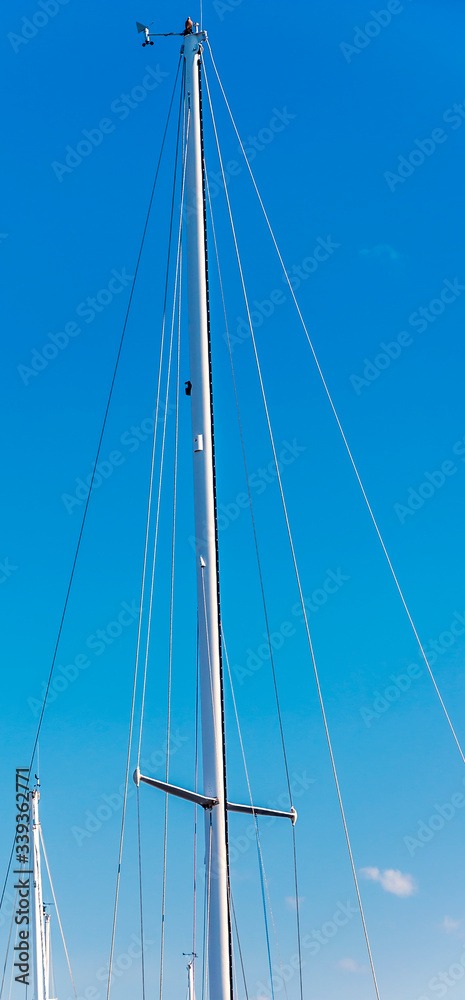 Sailboat mast against the clear blue sky Sailboat mast against the clear blue sky