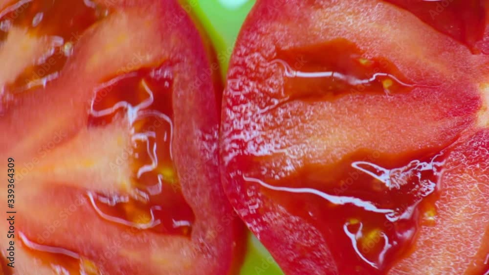 Closeup. Tomato slices rotate on a green background. top view Closeup. Tomato slices rotate on a green background. top view