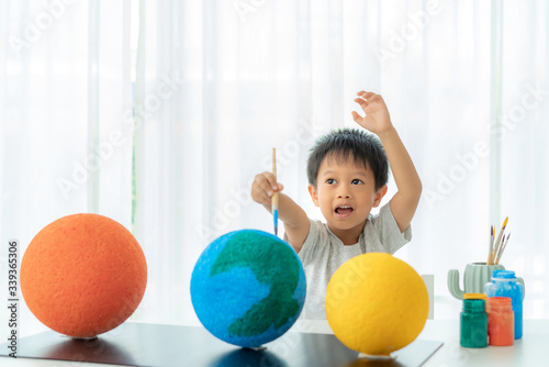 Asian preschool student boy painting the moon learning about the solar system at home, Homeschooling and distance learning