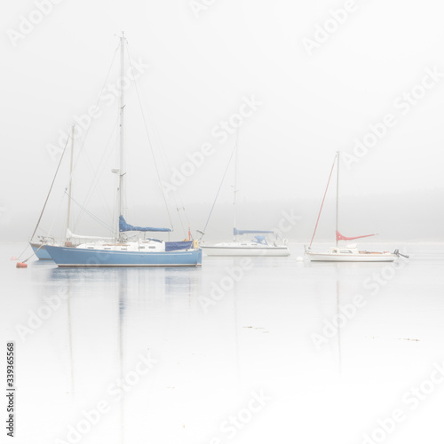 Sailing boats on misty lake