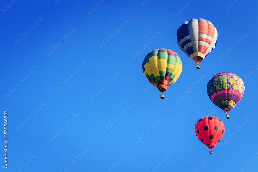 Colorful hot-air balloons flying in blue sky