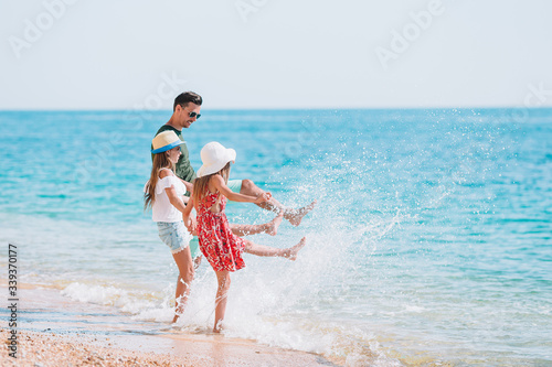 Adorable kids and their dad at beach during summer vacation