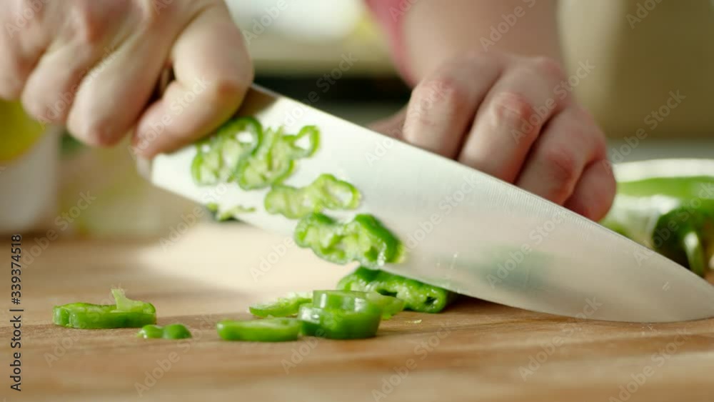 hands chopping green fresh pepper on a cutting board then throws peppers with a knife. Fast. hands chopping green fresh pepper on a cutting board then throws peppers with a knife. Fast.