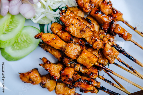 close-up grilled satay with cabbage, cucumber and onion