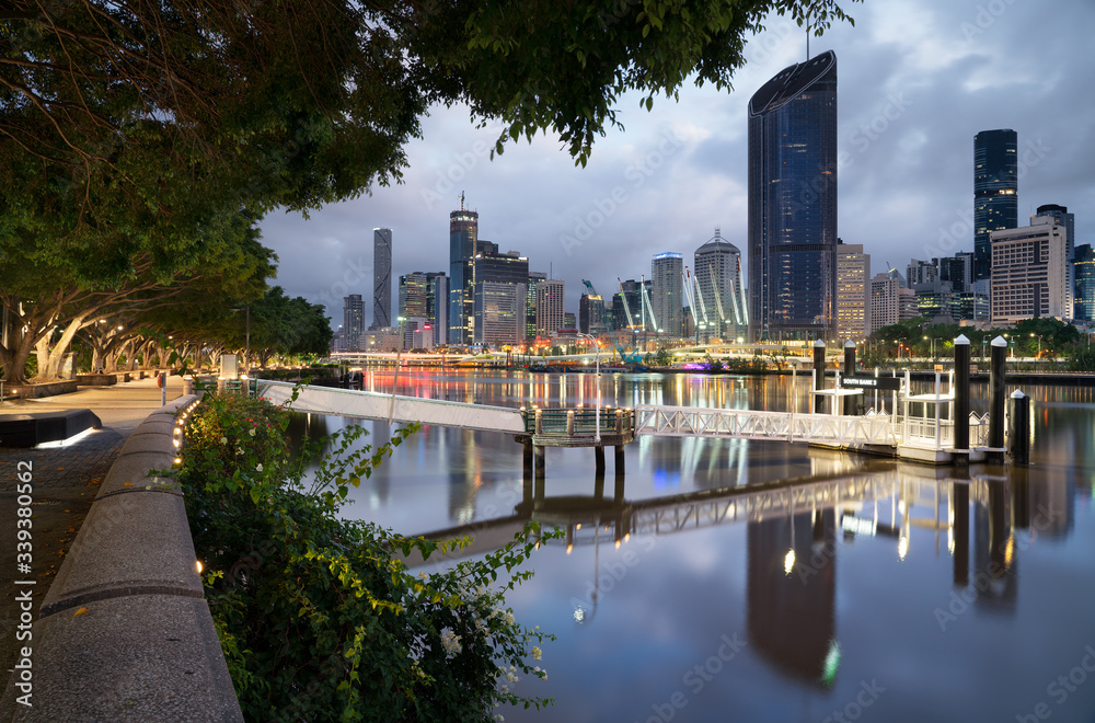 South bank Brisbane river boardwalk at sunrise with the city cat pier dock and city background