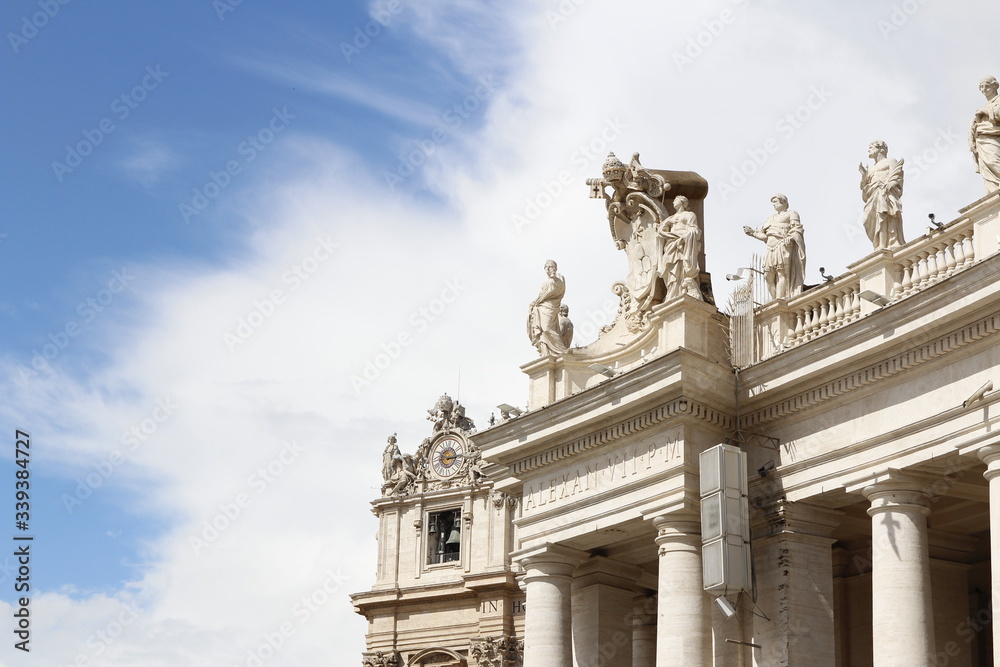 Obraz premium A group of Saint Statues on the colonnades of St Peter's Square with blue sky and clouds in Vatican City, Rome, Italy