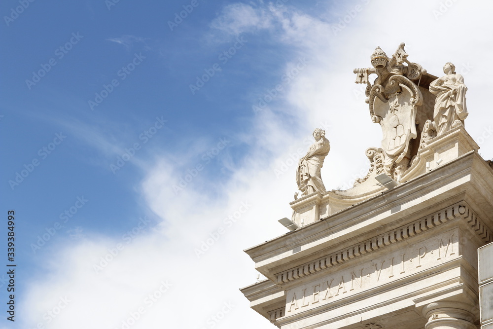 St. Agnes and St. Catherine on the colonnades of St Peter's Square with blue sky and clouds in Vatican City, Rome, Italy