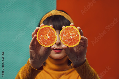 young woman holding oranges