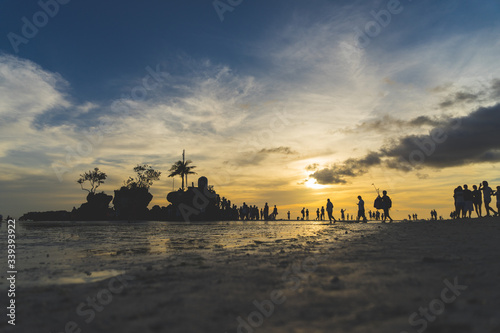sunset on the beach with people walking around