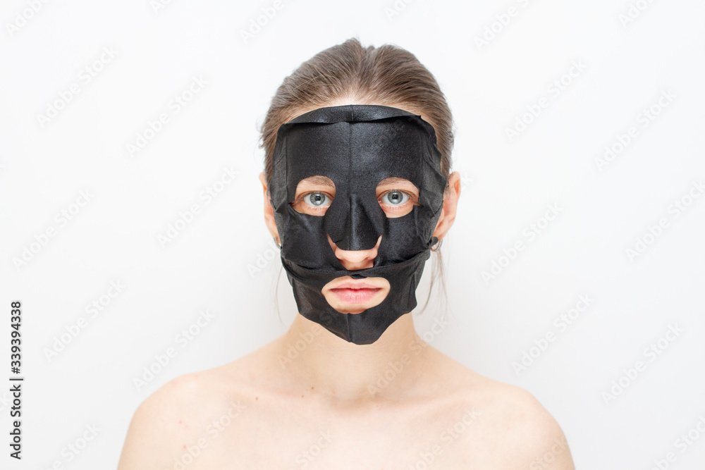 Girl with a black charcoal face mask for skin clean Girl with a black charcoal face mask for skin clean