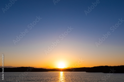 快晴の空の下に沈む夕日、狭山湖