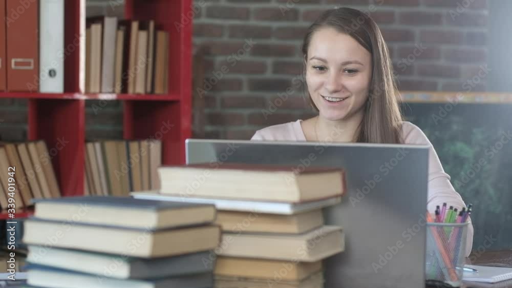 attractive Caucasian young girl is talking via video link with a teacher. Distance learning. The student communicates with the teacher online. Home schooling. Working at home during quarantine attractive Caucasian young girl is talking via video link with a teacher. Distance learning. The student communicates with the teacher online. Home schooling. Working at home during quarantine