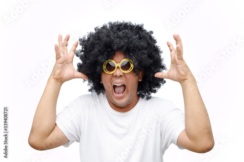 A man afro hair style is wearing a big yellow glasses with angry gesture.