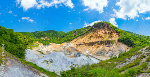 Panoramic view of Jigokudani valley or hell valley and blue sky background in summer. Natural Landscape and active volcano in Noboribetsu, Hokkaido, North of Japan.
