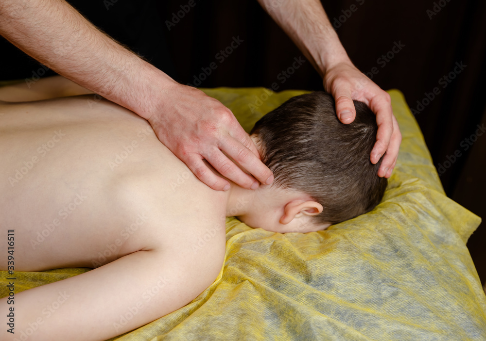 Boy having back massage in a children rehabilitation center Boy having back massage in a children rehabilitation center