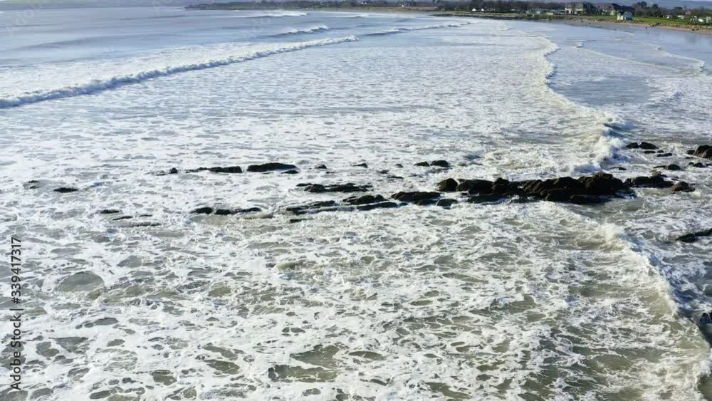 Ocean Surface waves crashing at rocks in Waterford, Ireland at day