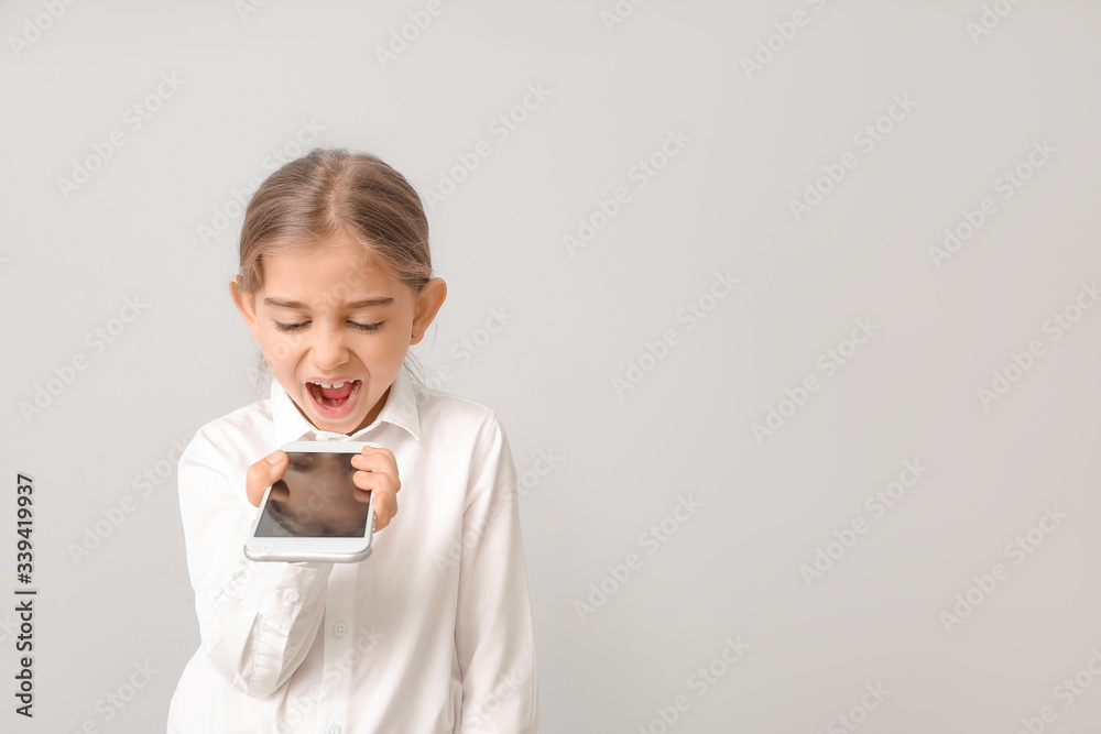 Angry businesswoman talking by mobile phone on light background Angry businesswoman talking by mobile phone on light background