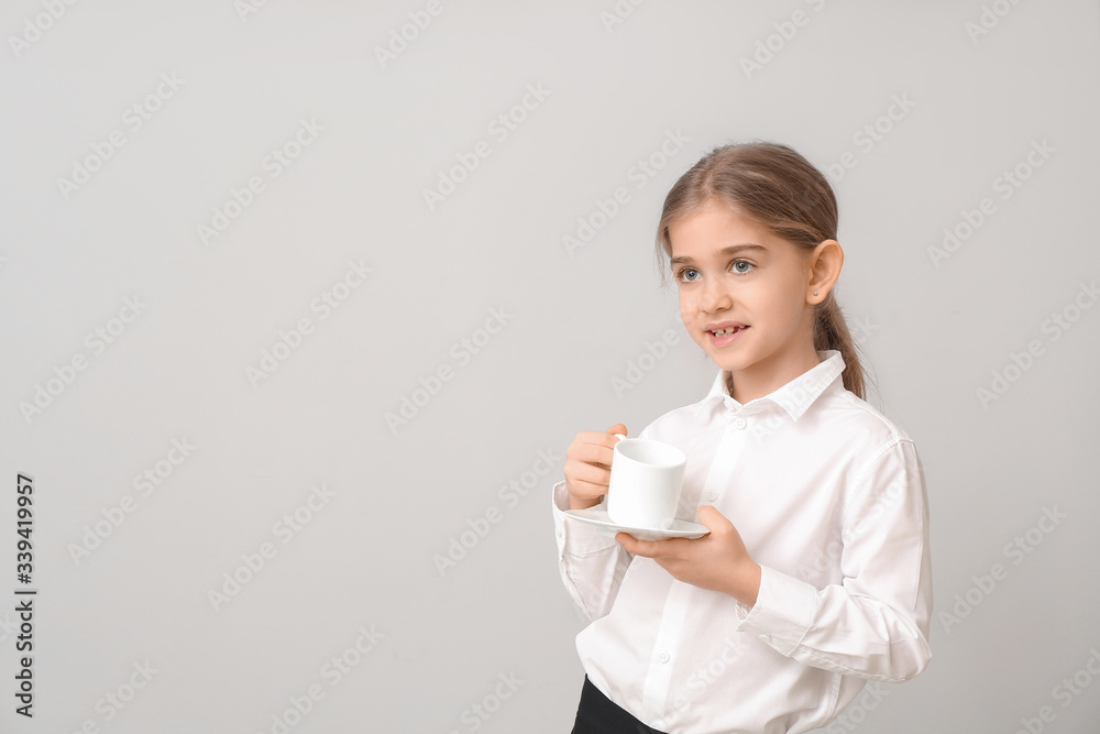 Little businesswoman with cup of coffee on light background Little businesswoman with cup of coffee on light background