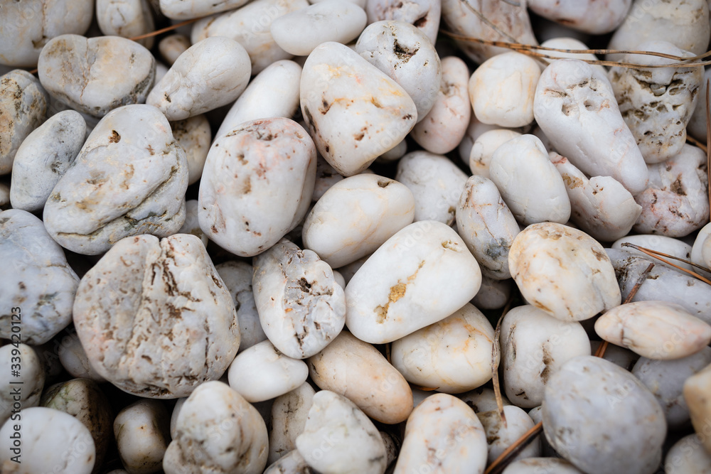 White smooth sea stones scattered with a slide. Background for nautical or home garden postcard White smooth sea stones scattered with a slide. Background for nautical or home garden postcard