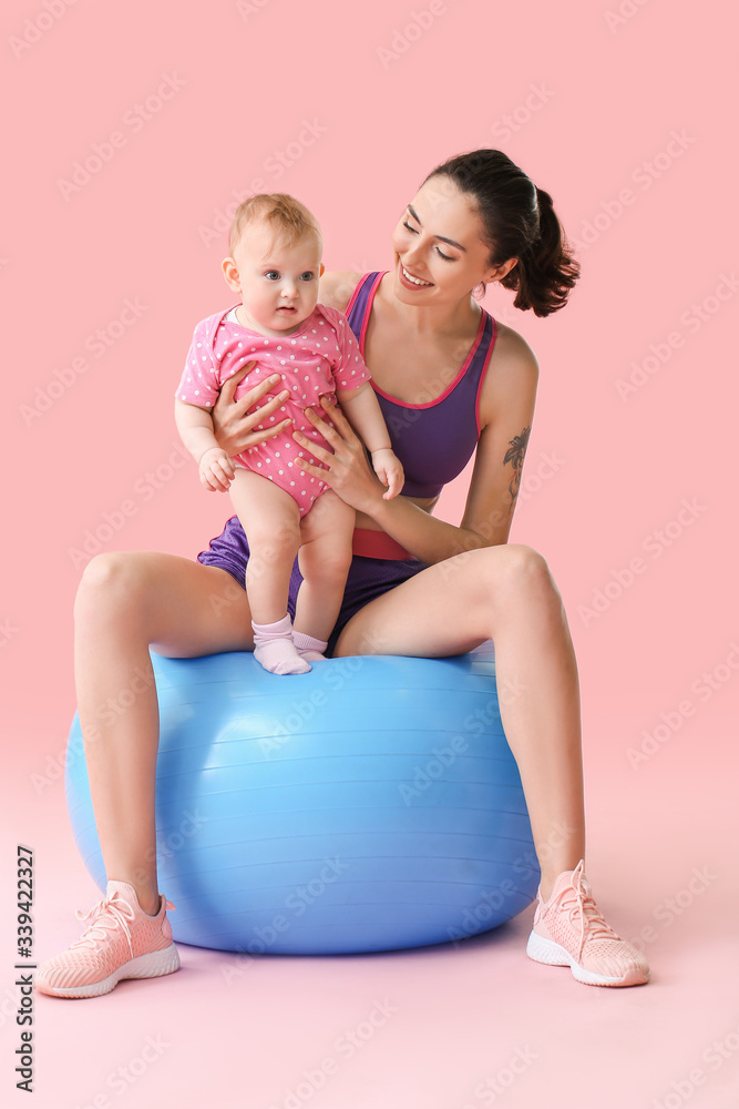 Young sporty mother and her baby doing exercises with fitball on color background Young sporty mother and her baby doing exercises with fitball on color background