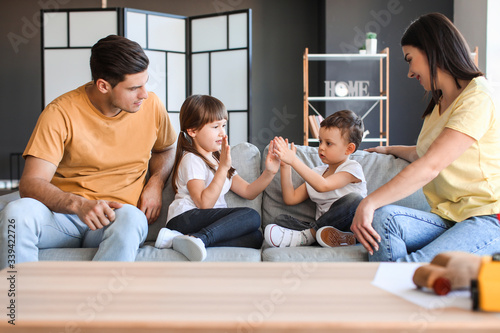 Happy family sitting on sof...