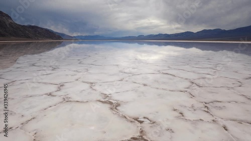 Walking in mirror surface of salt crust formations with water in Badwater Basin, Death Valley National Park. California, USA