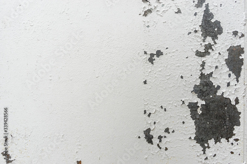 Old rusty steel surface closeup, metal wall with cracked weathered white paint. Abstract grunge texture as background for your design with copy space and place for text