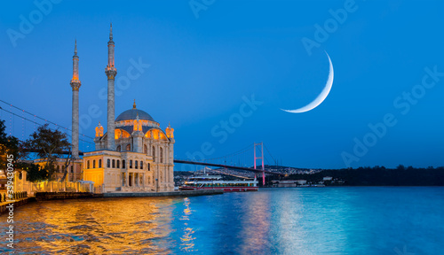 Ortakoy mosque and Bosphorus bridge at amazing sunset with crescent moon - Istanbul, Turkey