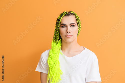 Portrait of young transgender woman on color background