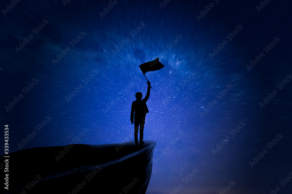 Success Concept, Silhouette of young men and flag are celebrating success on top of hill, sky and sun light background. Business, successful, leadership, achievement, and goal concept.