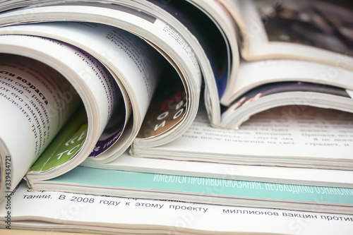 a stack of open glossy magazines lies on the table