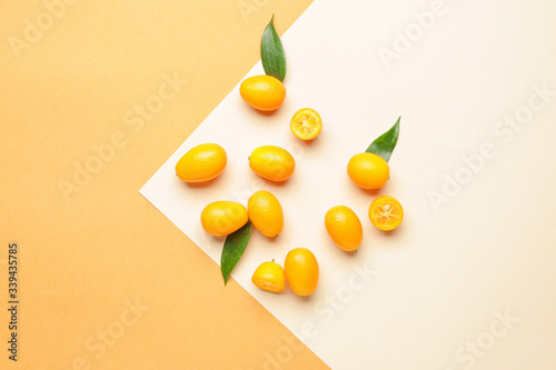 Tasty kumquat fruit on color background