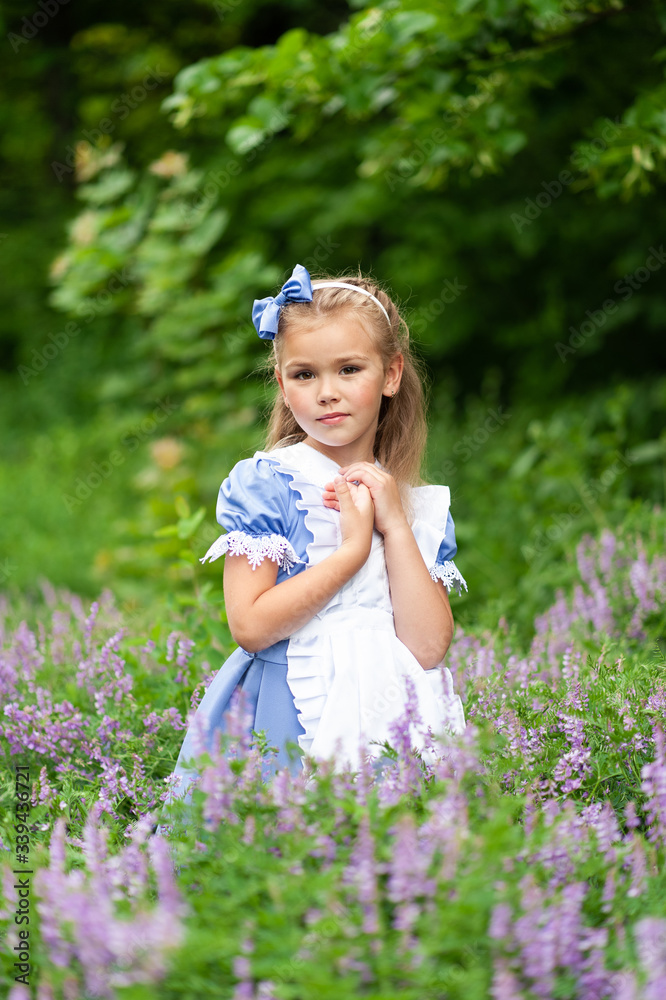 Portrait of a little cute girl dressed as Alice. Stylized photo shoot in nature. Portrait of a little cute girl dressed as Alice. Stylized photo shoot in nature.