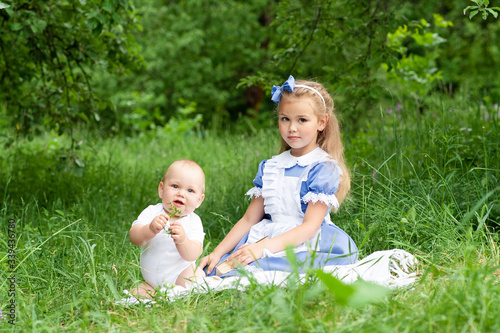 Little cute girl and her little brother have a picnic in the park.