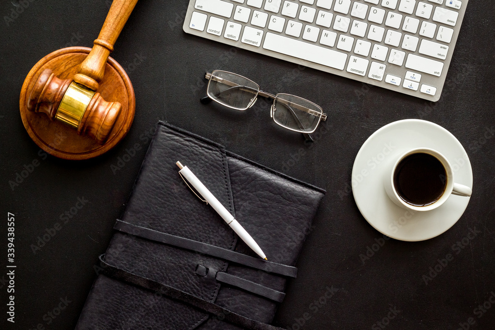 Law student office flat lay with judge hammer, keyboeard, notebook. Black, top-down
