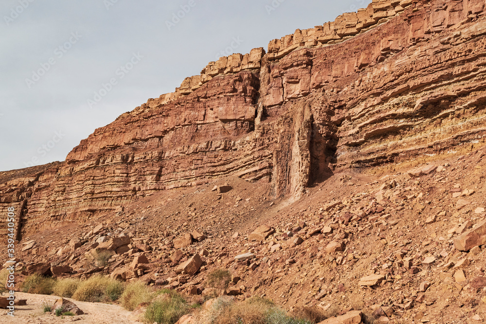 geological detail of the cliff next to wadi ardon in the makhtesh ramon crater showing two magma dikes with the stream bed in the foreground geological detail of the cliff next to wadi ardon in the makhtesh ramon crater showing two magma dikes with the stream bed in the foreground