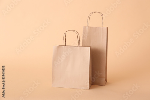 Paper shopping bags on color background