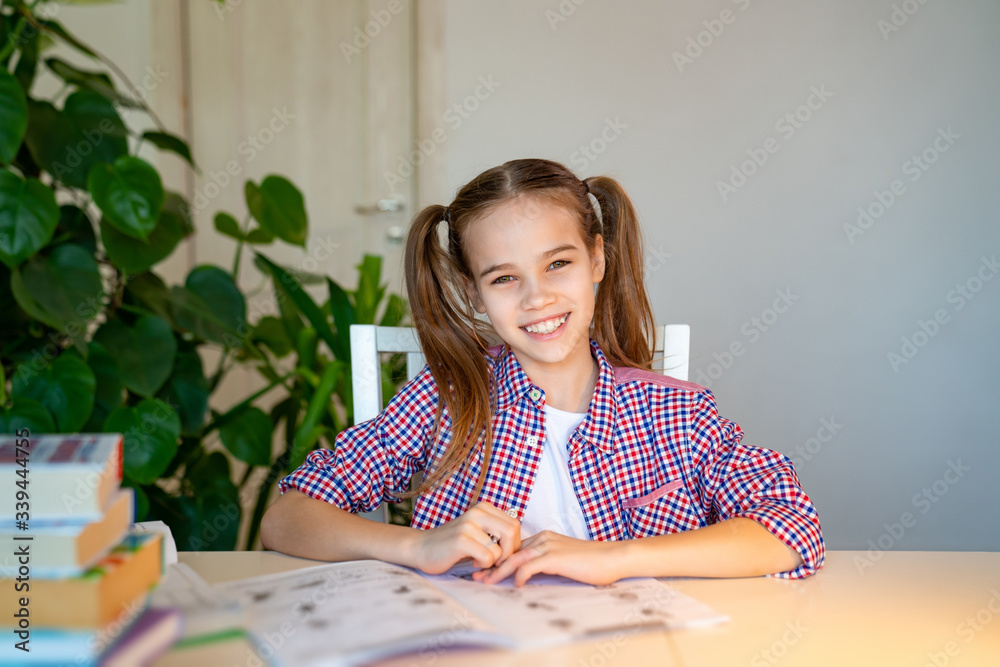 schoolgirl in a plaid shirt doing homework schoolgirl in a plaid shirt doing homework
