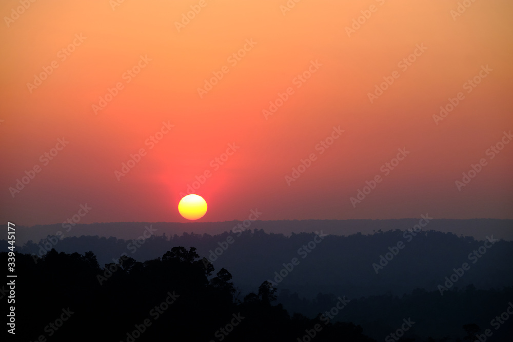 Beautiful sunset over a misty mountains. View of valley with silhouette of mountains ridge on backdrop. Beautiful sunset over a misty mountains. View of valley with silhouette of mountains ridge on backdrop.