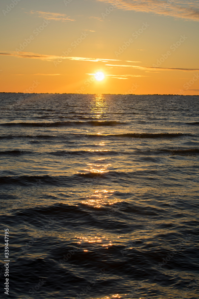 Fototapeta premium Beautiful orange sunset at sea. Sunlight shining over water
